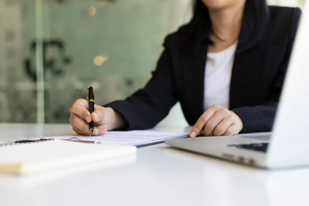 An attorney working at her desk about to write on some paperwork.