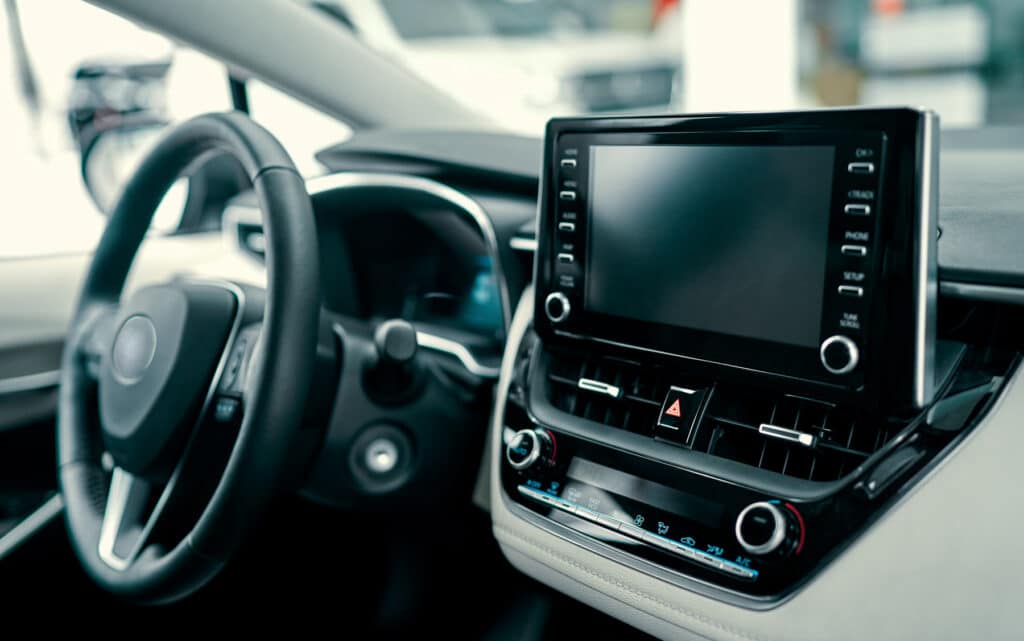 A touchscreen display in the centre console of an ordinary car interior